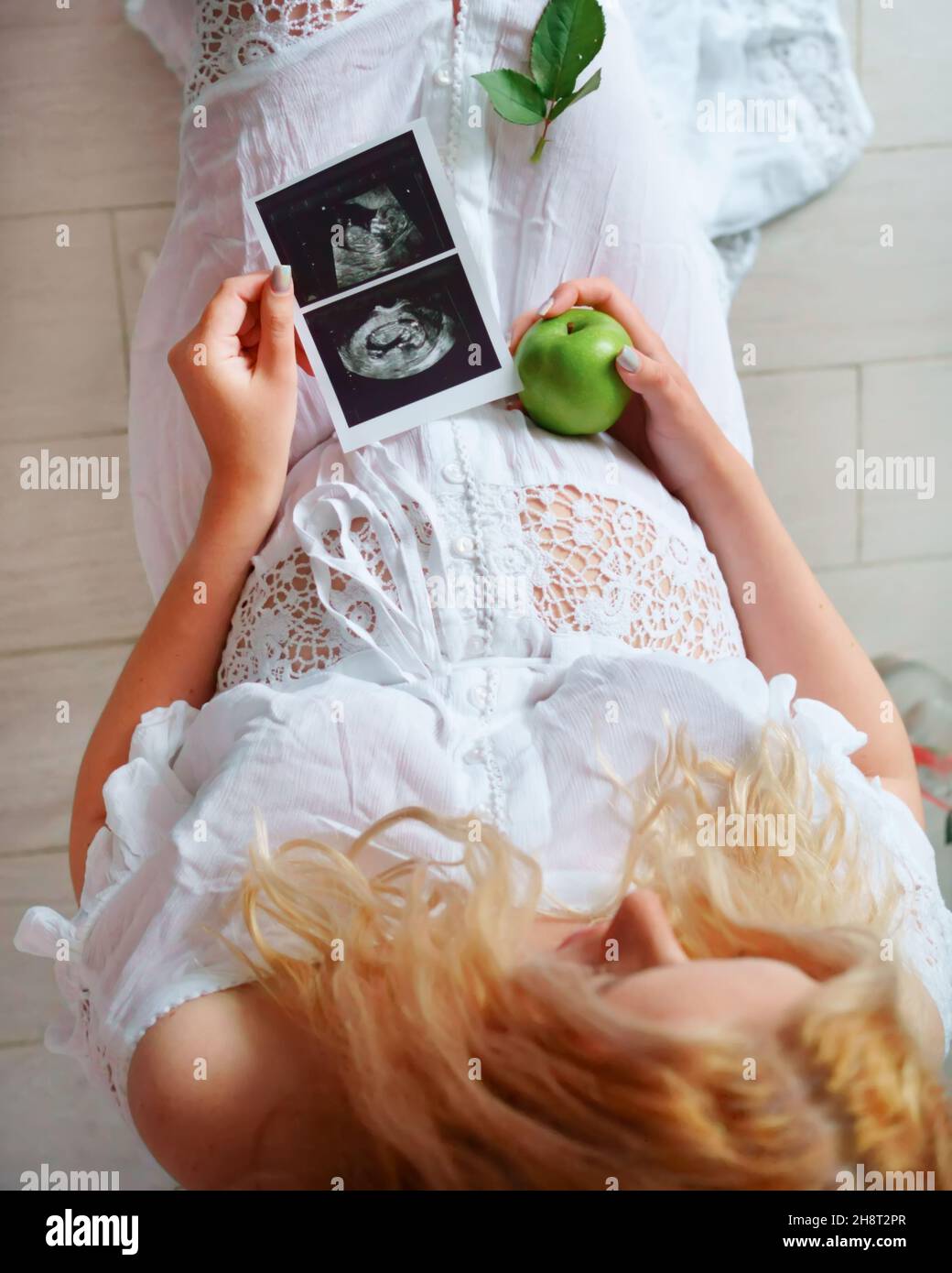 A pregnant woman received an ultrasound scan result, found out the gender of the child. Healthy motherhood, ecology. Stock Photo