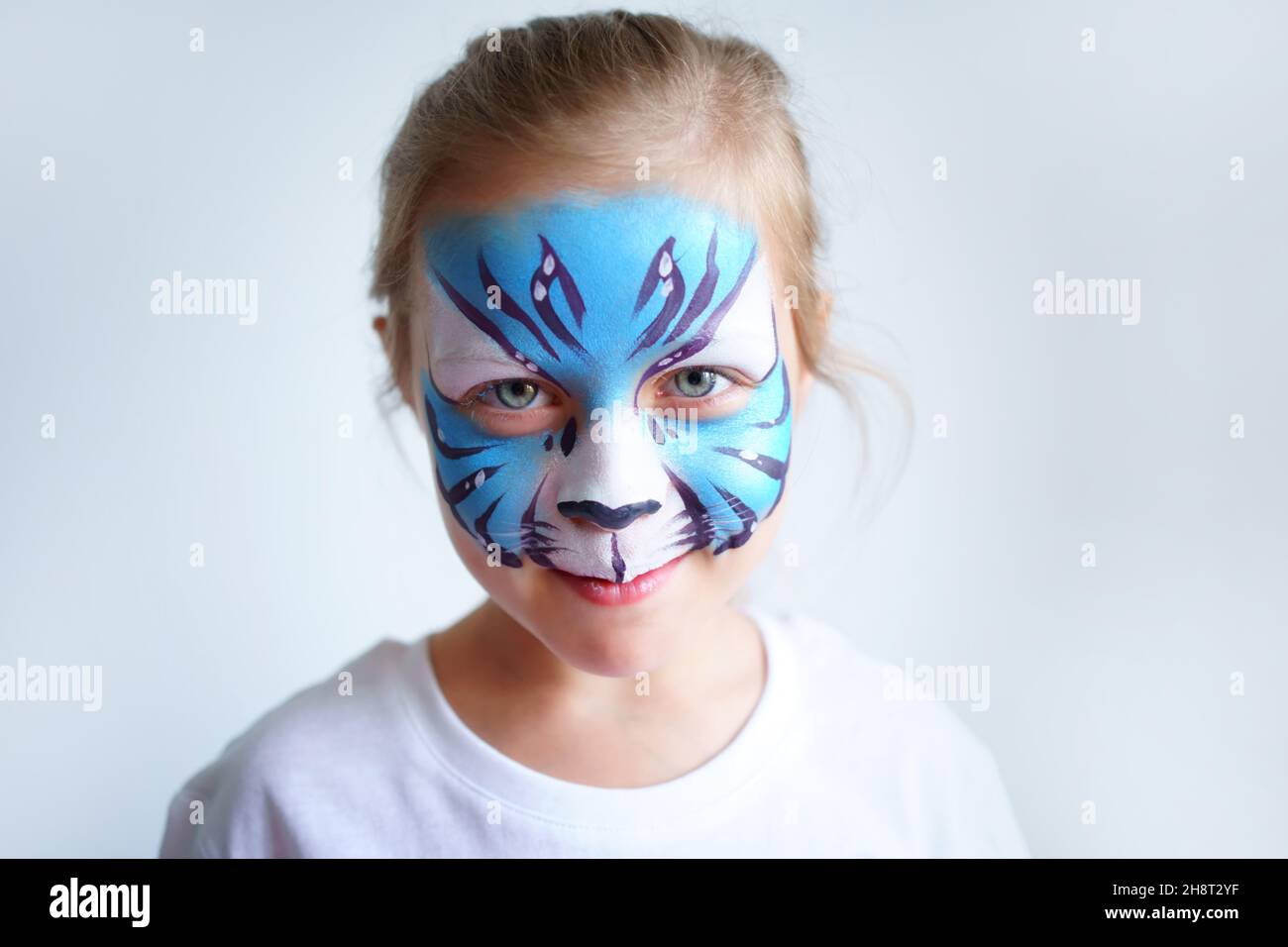 Girl aqua makeup in the form of a blue water tiger zodiac on a white background, concept symbol of the new year 2022, smile portrait Stock Photo