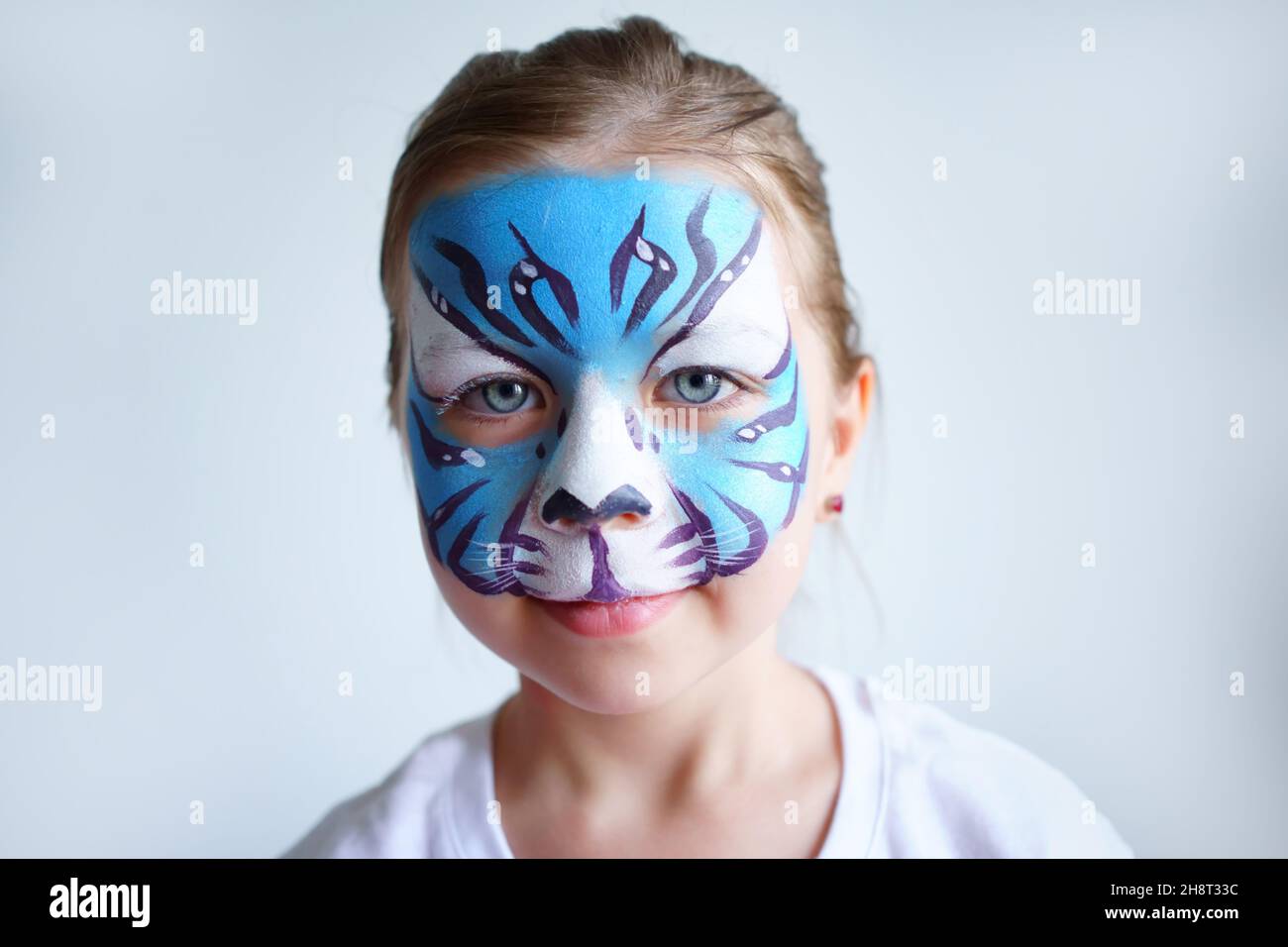 Girl aqua makeup in the form of a blue water tiger zodiac on a white background, concept symbol of the new year 2022, smile portrait Stock Photo