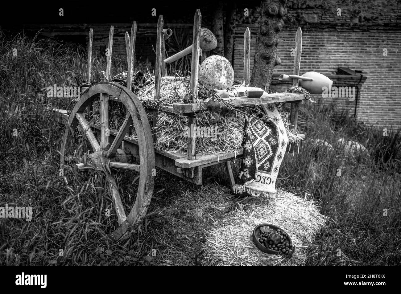Wooden cart loaded with hay in the town of Signagi. Kakheti Province, Georgia. Black and white. Stock Photo