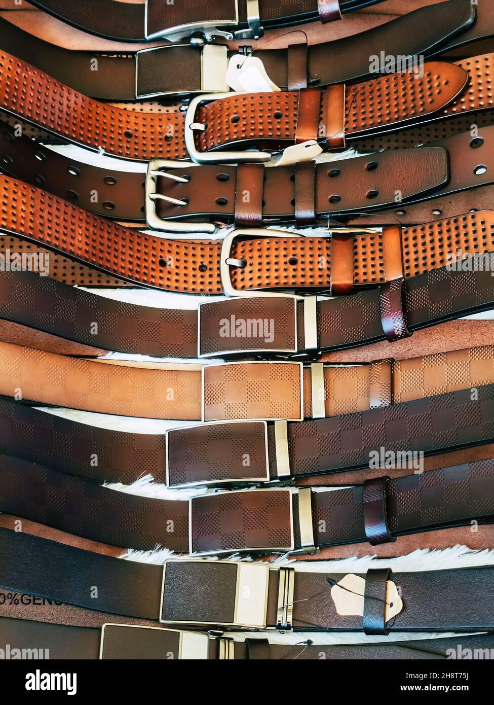 Various types of brown leather belt in a row for display and sale on the market. Realistic leather belts set with metal buckles. Clothing store shelf Stock Photo Alamy