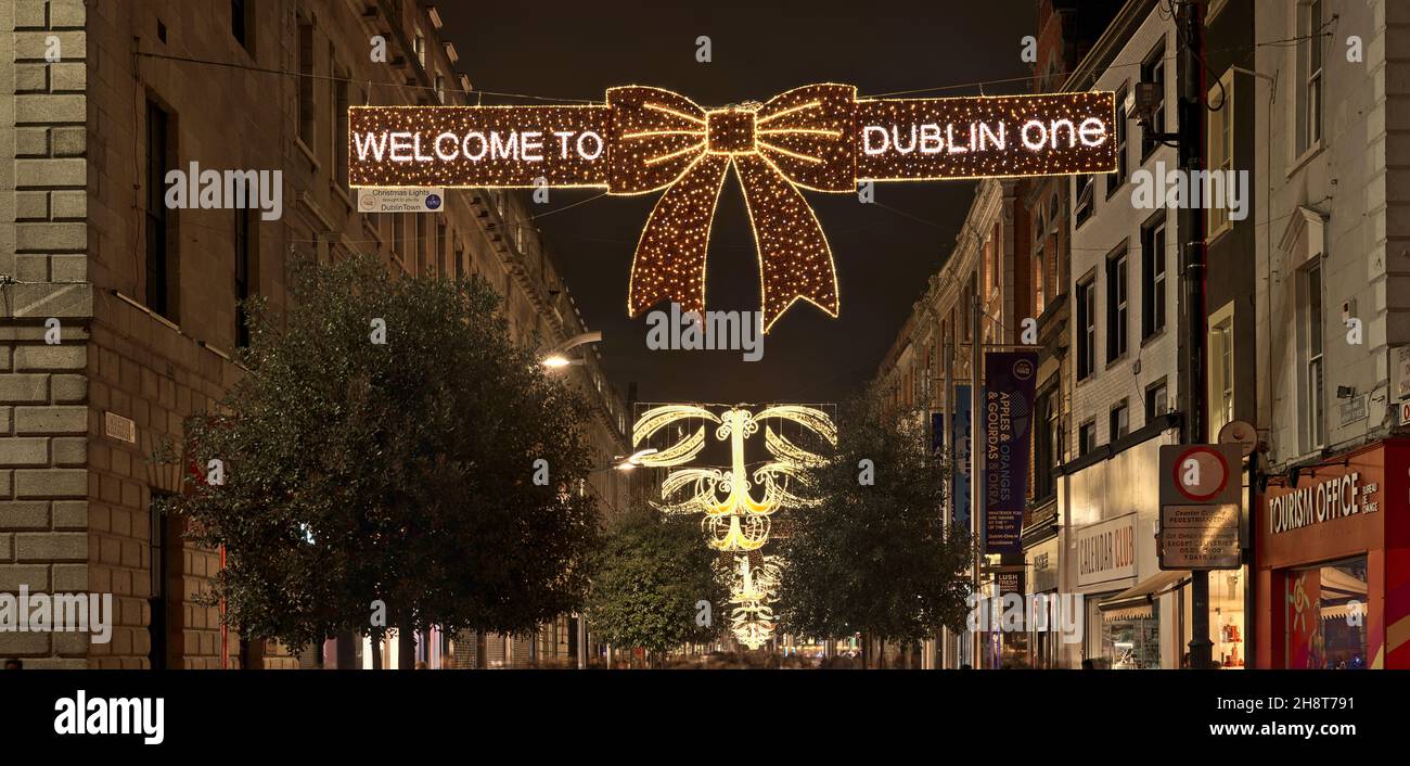 Dublin, Ireland - November 13, 2021: Beautiful panoramic view of festive Christmas lights with 'Welcome to Dublin one' sign on busy Henry Street Stock Photo