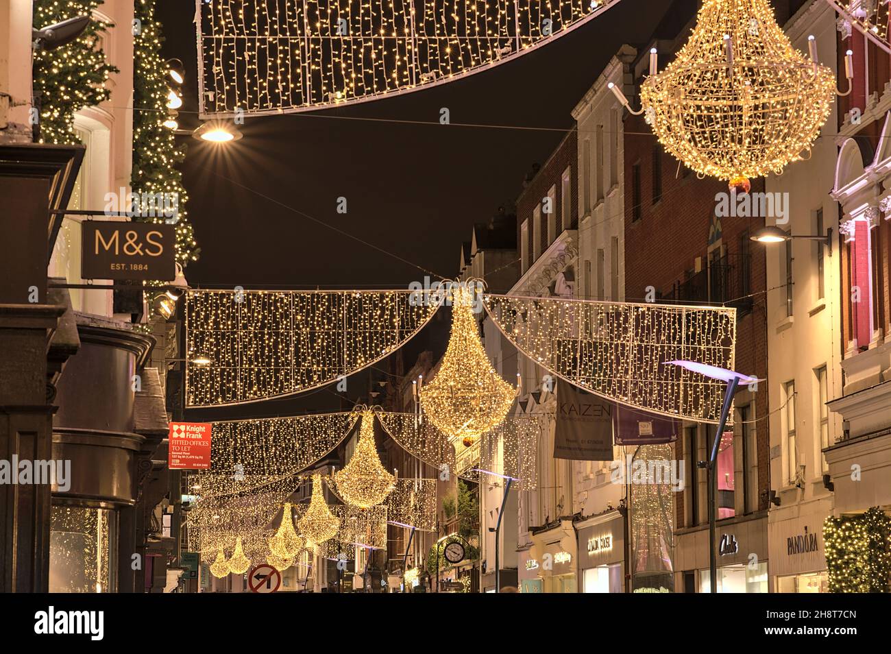 Dublin, Ireland - November 13, 2021: Closeup evening view of Christmas lights decorations on Grafton Street. Crowded street during COVID pandemic Stock Photo