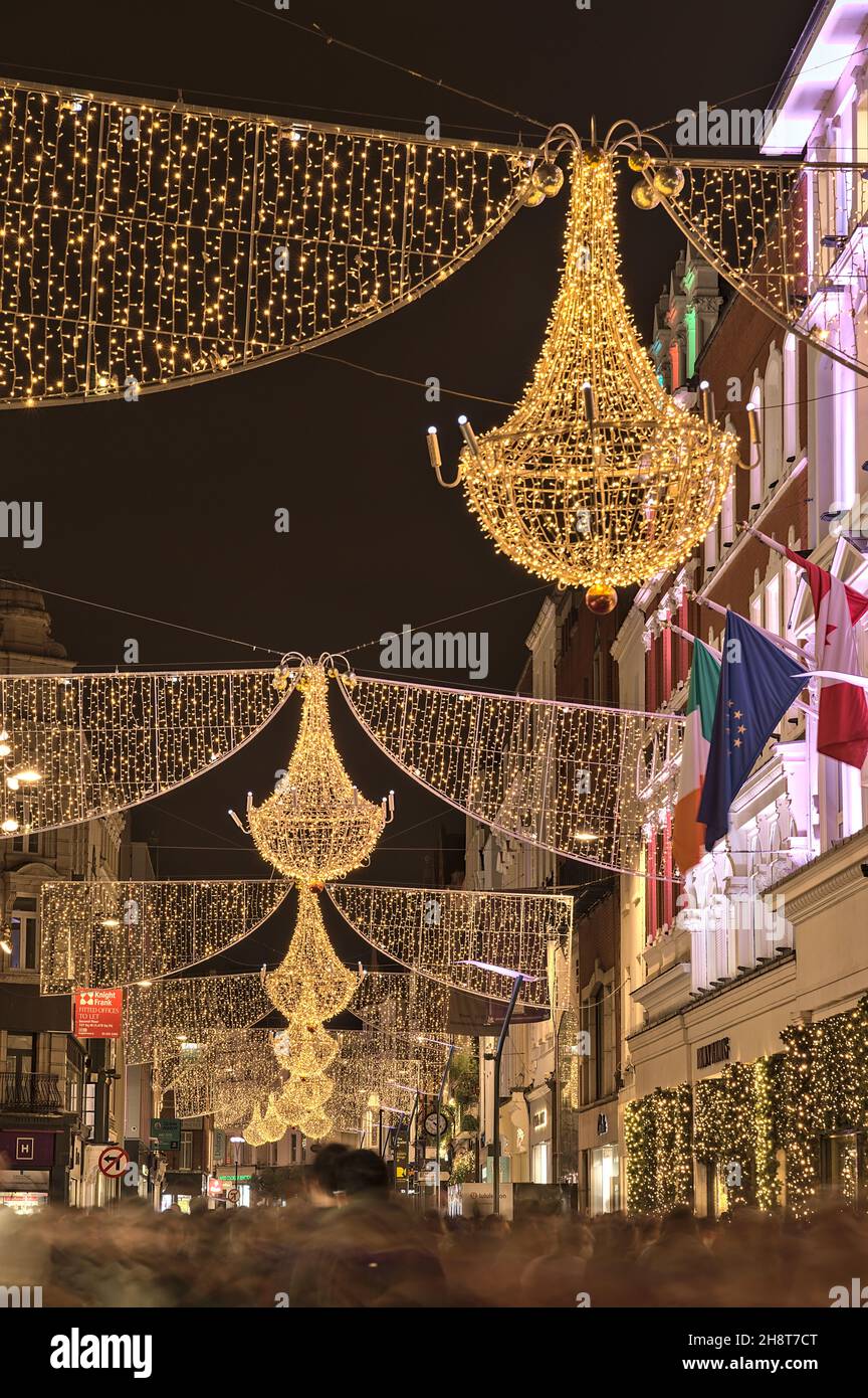 Dublin, Ireland - November 13. 2021: Closeup evening view of Christmas lights decorations on Grafton Street. Crowded street during COVID pandemic Stock Photo