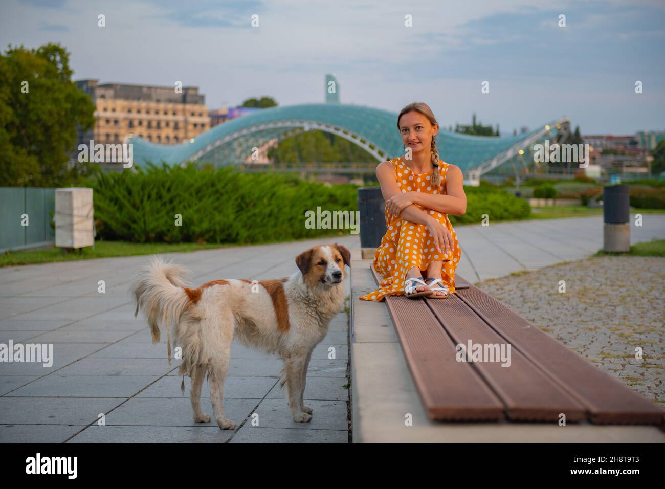 in the park a girl sits on a bench with a dog in tbilisi Stock Photo ...