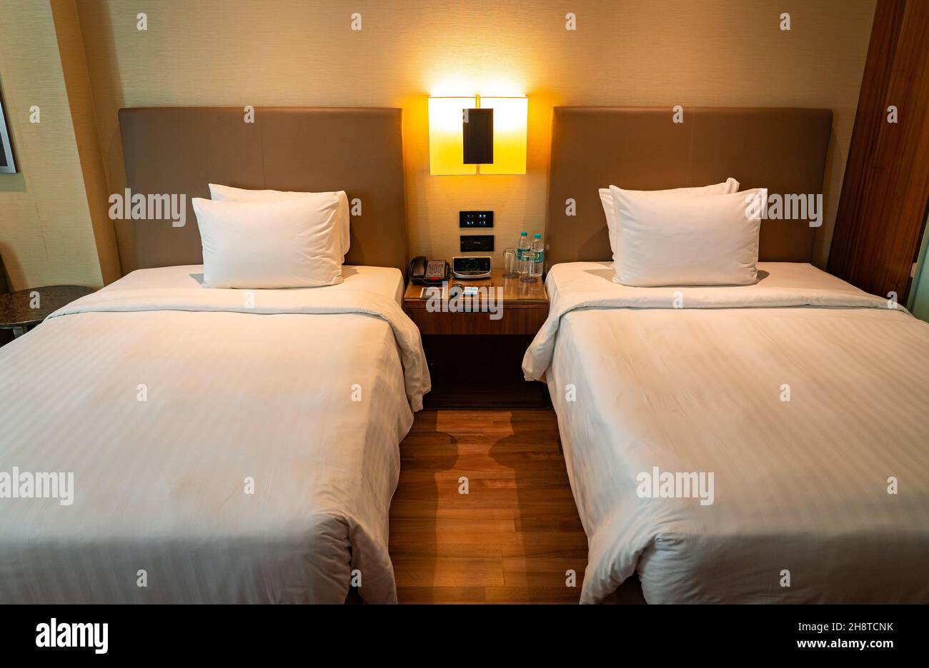 A deluxe hotel room with two luxury twin beds offering space and comfort for business and leisure travelers. Stock Photo