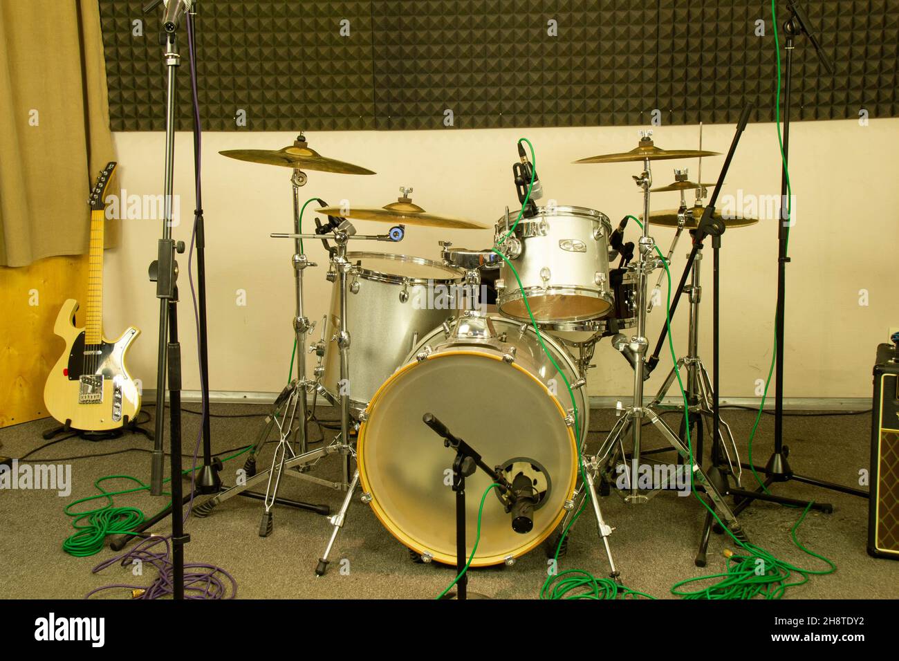 Drum kit and yellow electric guitar in a professional music studio