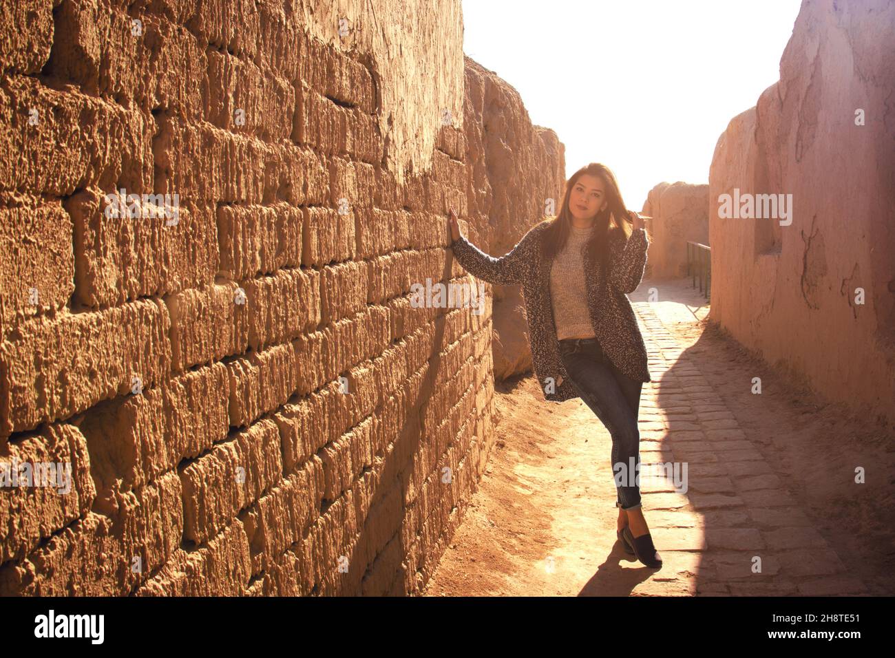 a young lady in an ancient street in Nisa, Turkmenistan at sunset Stock Photo