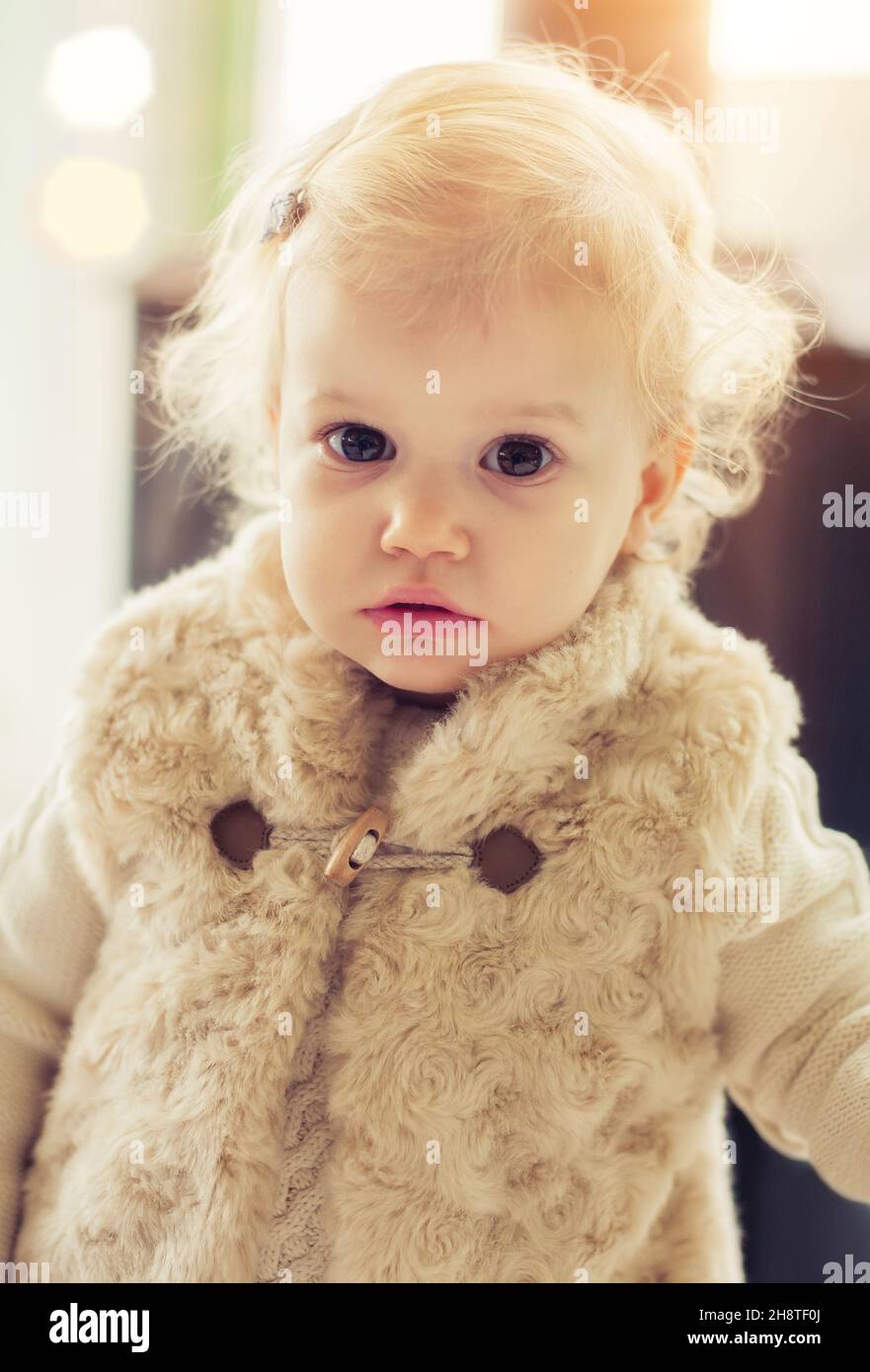 Cute baby girl posing indoors in fancy clothes Stock Photo
