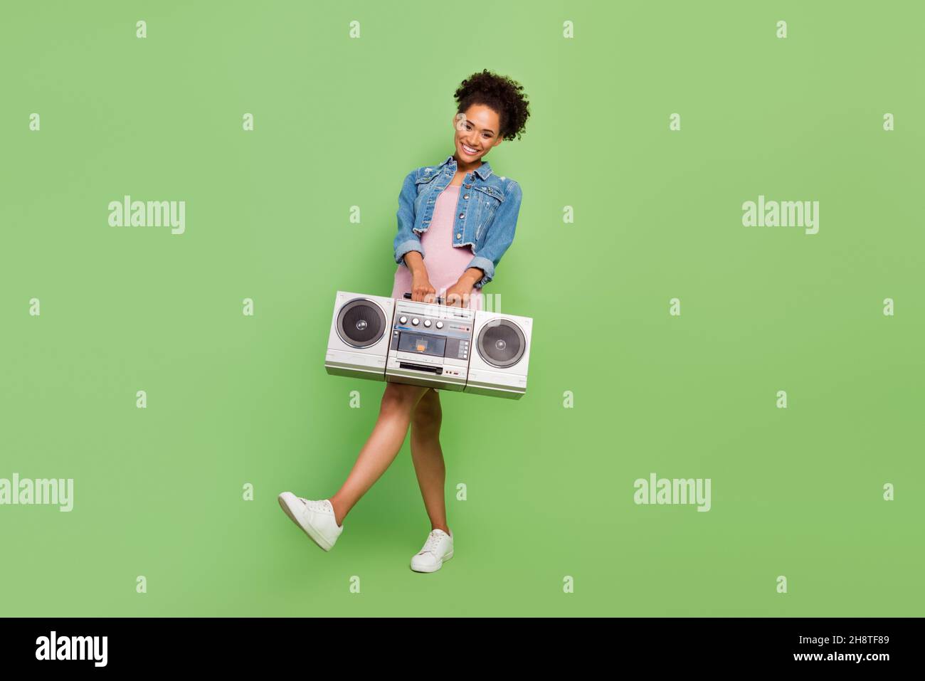 Full body photo of nice millennial lady with boom box wear dress shirt sneakers isolated on green background Stock Photo