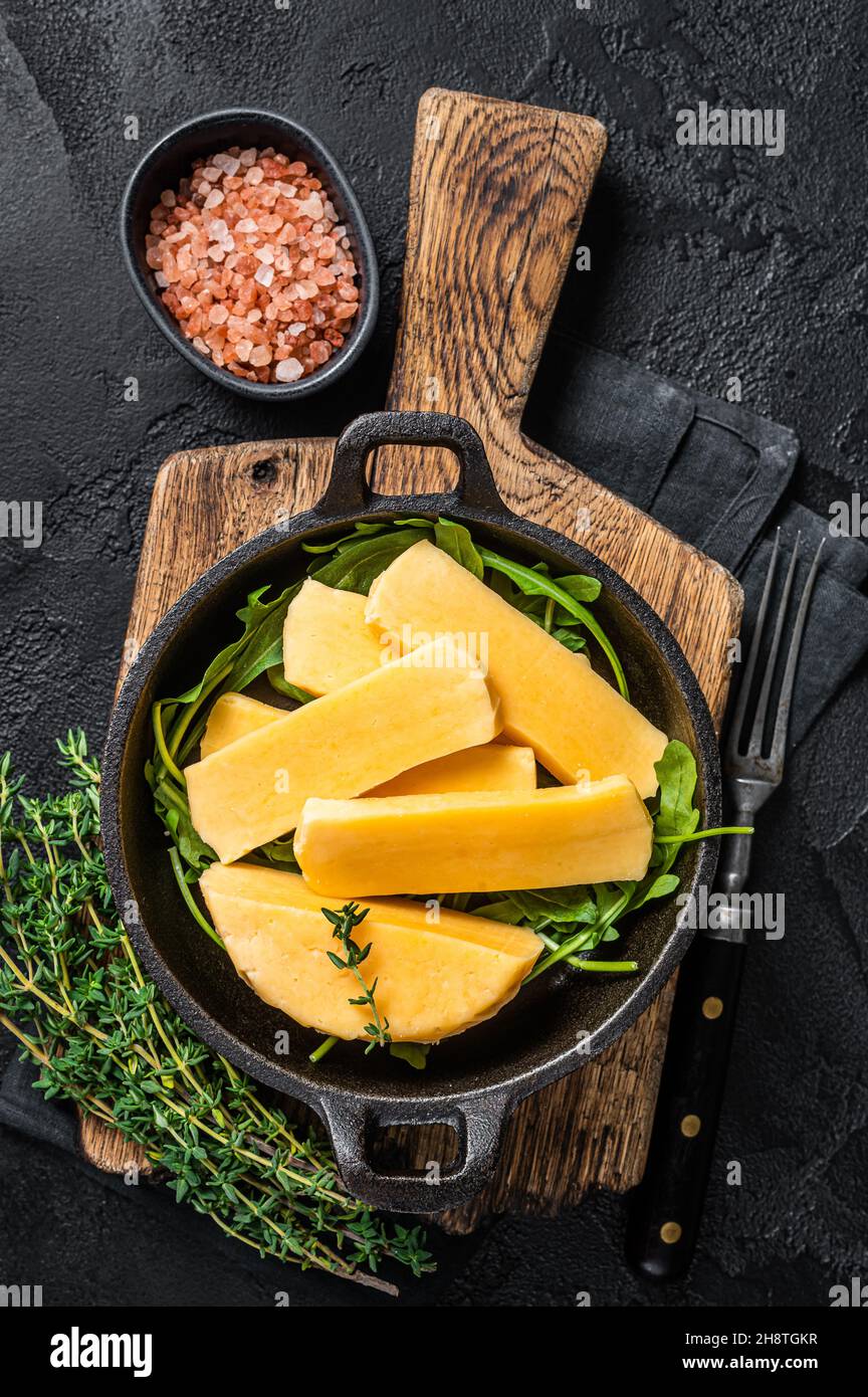 Halloumi cheese in pan ready for grilling. Black background. Top view Stock Photo