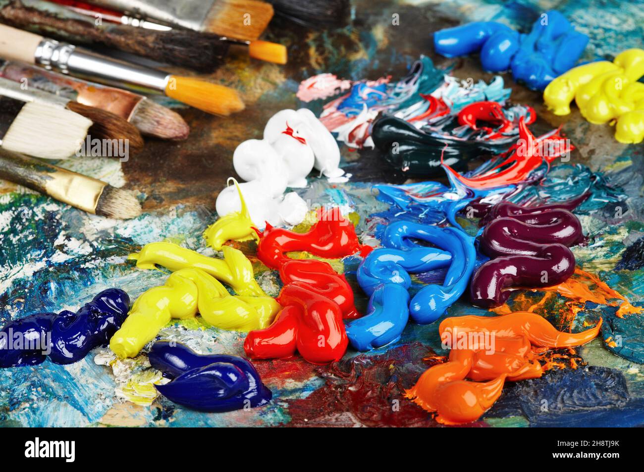 Artist paint brushes and oil paint tubes on wooden palette. Texture mixed  oil paints in different colors. Instruments and tools for creative leisure  Stock Photo - Alamy