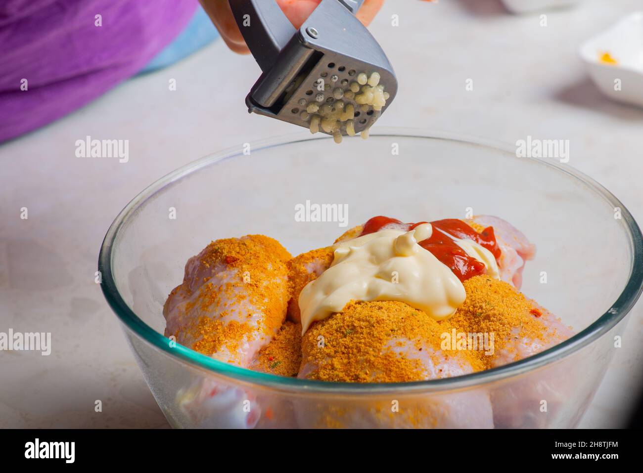 chicken drumsticks in a cup add garlic Stock Photo