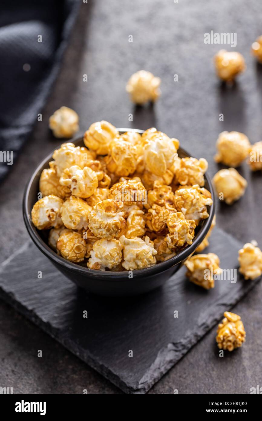 Sweet caramel popcorn in bowl on black table. Stock Photo