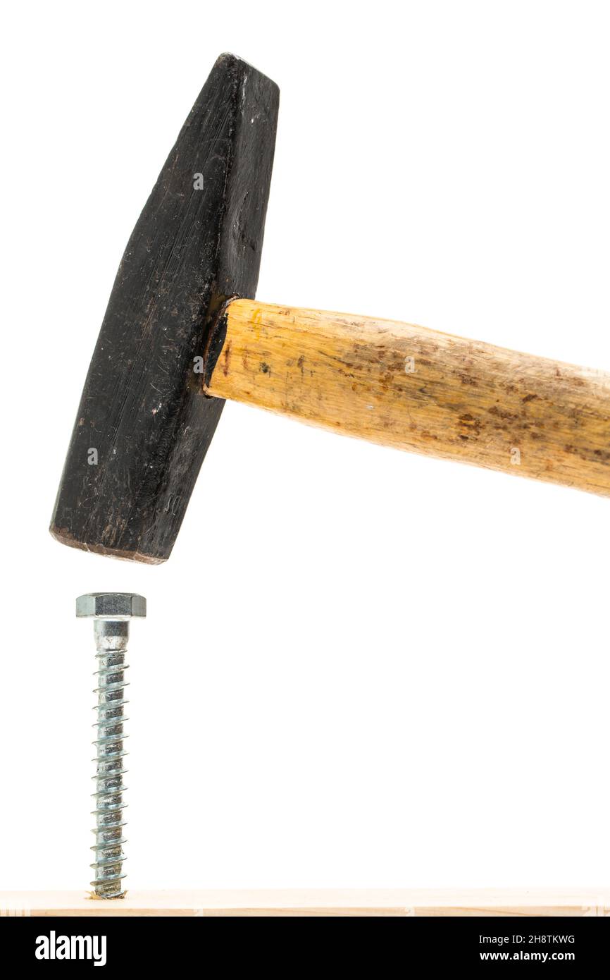 Drive screw in with a hammer - the wrong tool Stock Photo