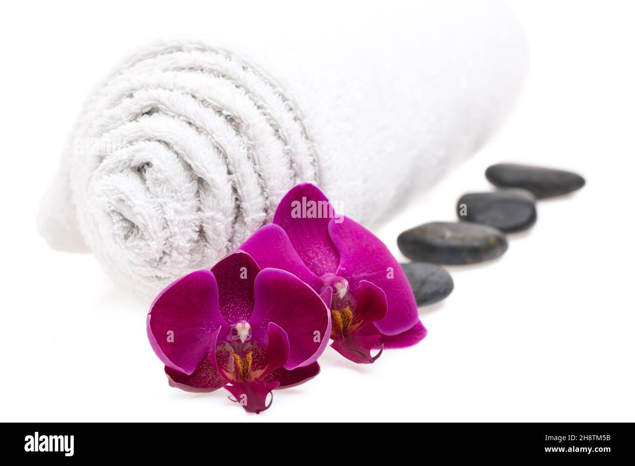 Towel, stones and flowers isolated on white background Stock Photo