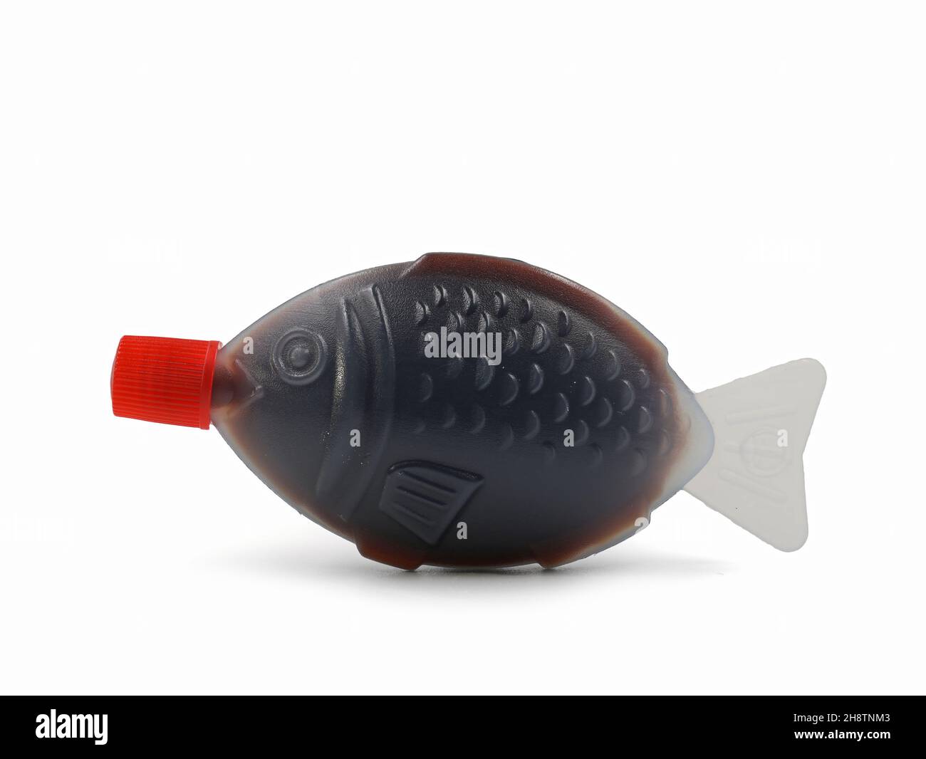 Fish shaped plastic takeaway container serving of soy sauce isolated on a white background Stock