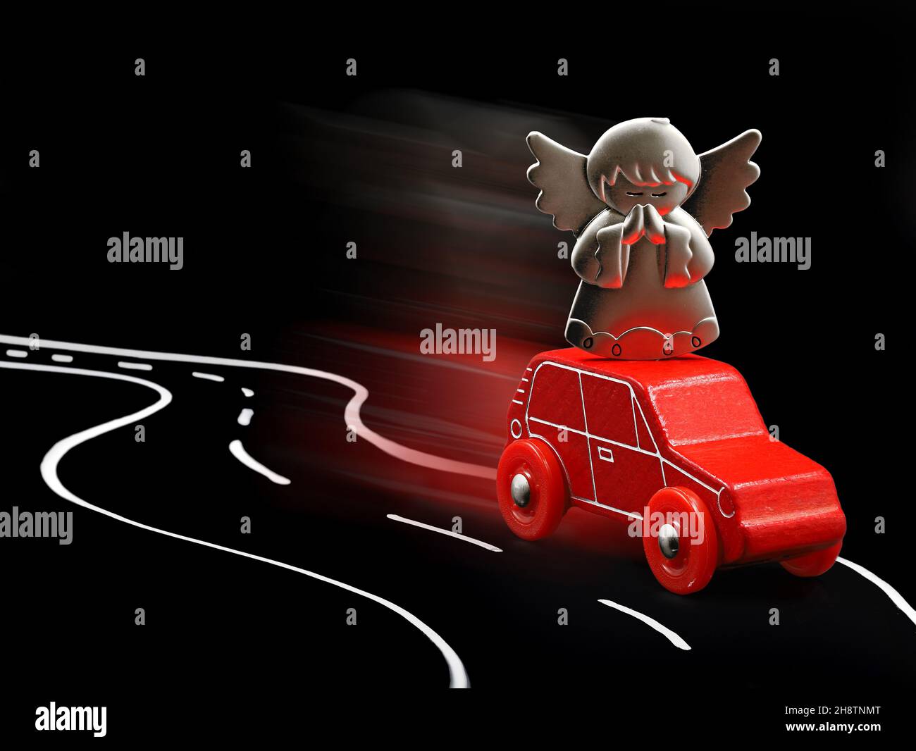 Guardian angel protects red car in road traffic, concept image on black