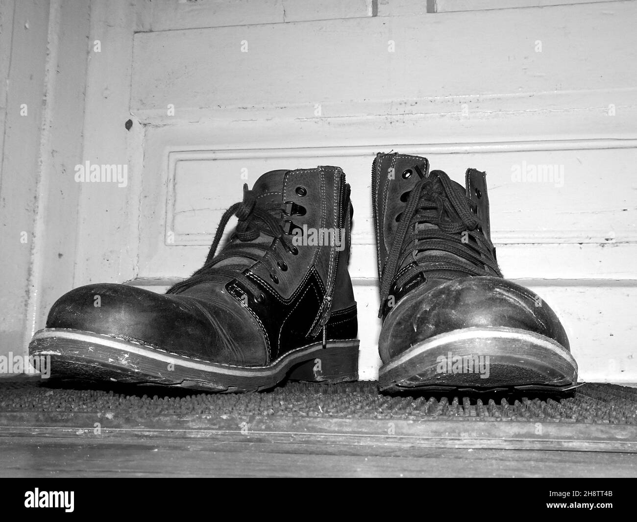 Old muddy boots in black and white Stock Photo