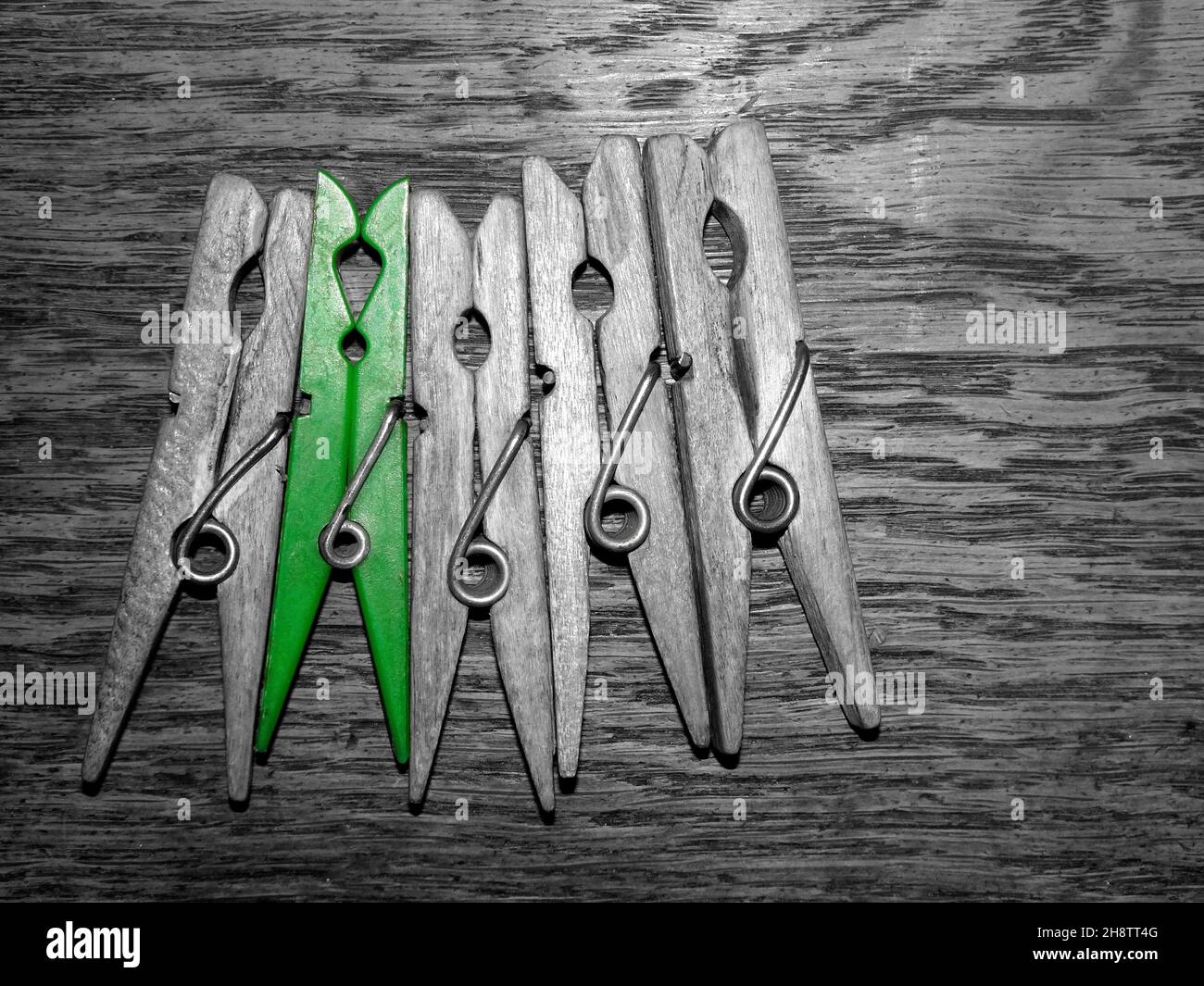 A row of cloth pegs on wooden background. Selective color Stock Photo