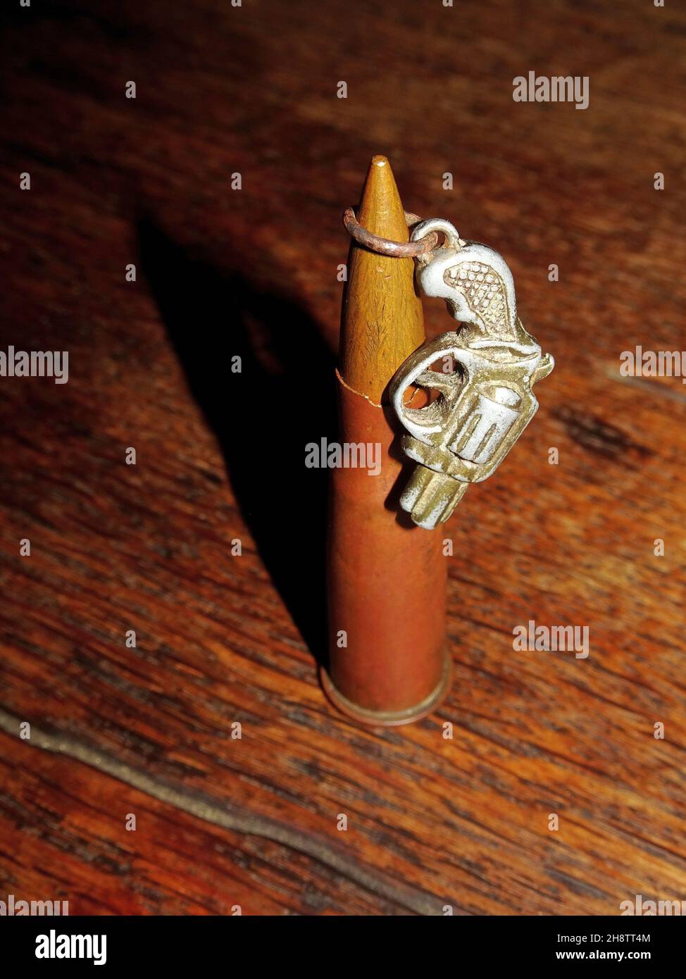 Vintage bullet and small toy gun on old wooden table Stock Photo