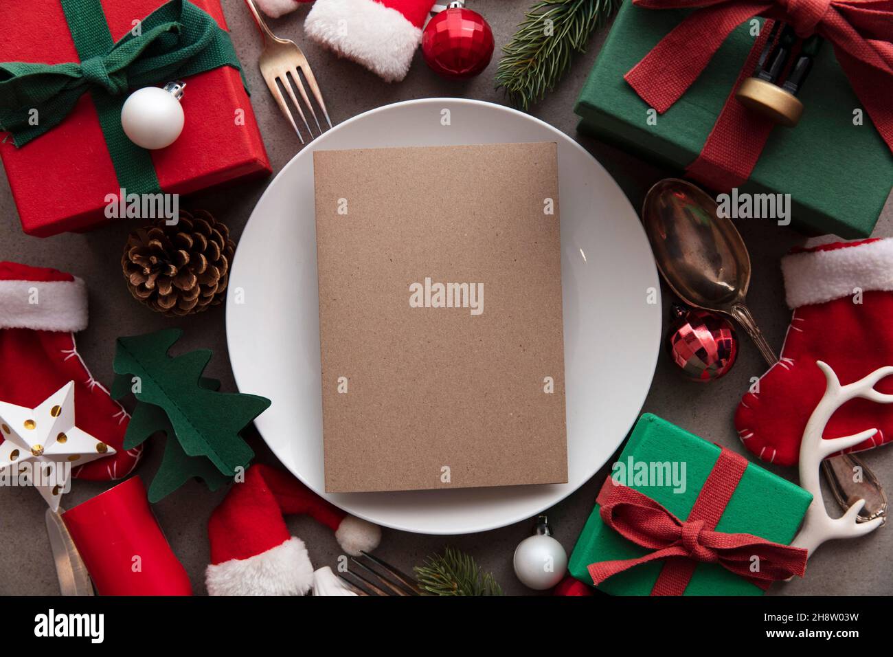 Christmas meal blank menu. Blank paper menu on a dinner plate surrounded by festive decorations Stock Photo
