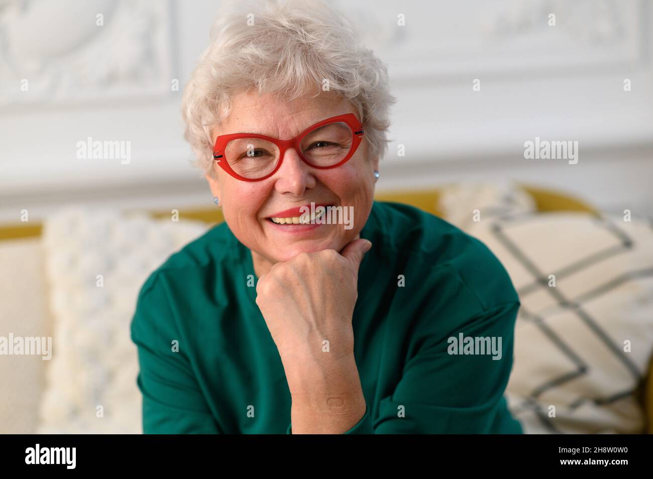 Smiling 60s middle aged woman looking at camera. Happy mature elegant old lady posing at home. Headshot close up portrait Stock Photo