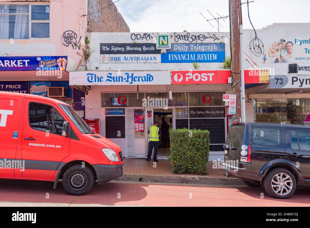 An Australia Post worker waits outside the Pymble news agency Post Office during the Sydney Covid-19 Delta lockdown in Australia Stock Photo