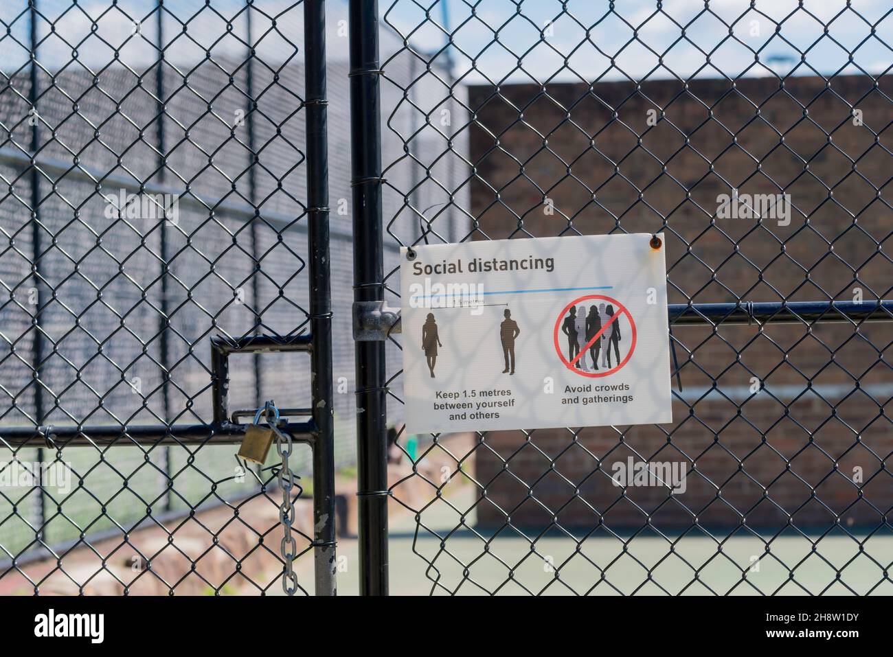 A social distancing Covid-19 sign at the gate to a tennis court in Sydney, Australia Stock Photo