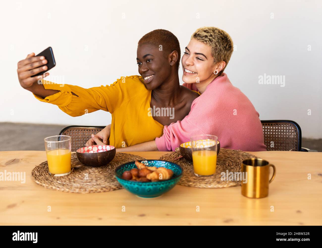 Multiethnic couple taking a selfie while having dinner Stock Photo