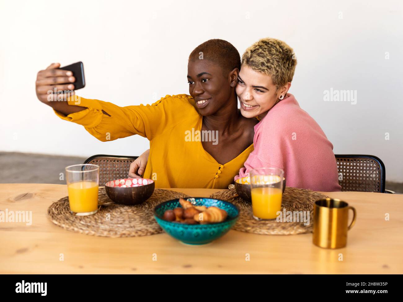 Multiethnic couple taking a selfie while having dinner Stock Photo