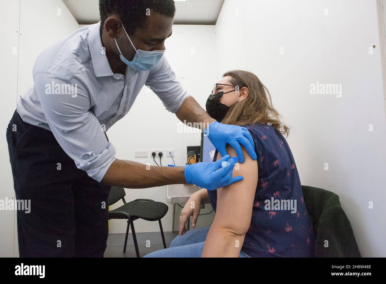 London, UK, 2 December 2021: Helen Eastman, 42, receives her Pfizer booster jab at Pearl Chemists pop-up vaccination centre in Tooting, south London. The government have promised to offer all adults a third vaccination dose by the end of January 2022 in the face of fears that the omicron varant could spread rapidly once it starts community transmission in the UK. Anna Watson/Alamy Live News Stock Photo