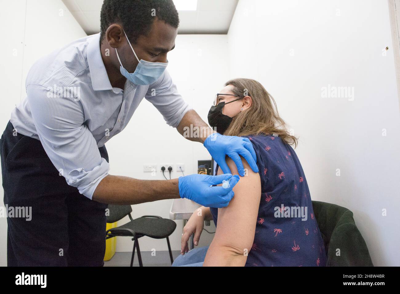 London, UK, 2 December 2021: Helen Eastman, 42, receives her Pfizer booster jab at Pearl Chemists pop-up vaccination centre in Tooting, south London. The government have promised to offer all adults a third vaccination dose by the end of January 2022 in the face of fears that the omicron varant could spread rapidly once it starts community transmission in the UK. Anna Watson/Alamy Live News Stock Photo