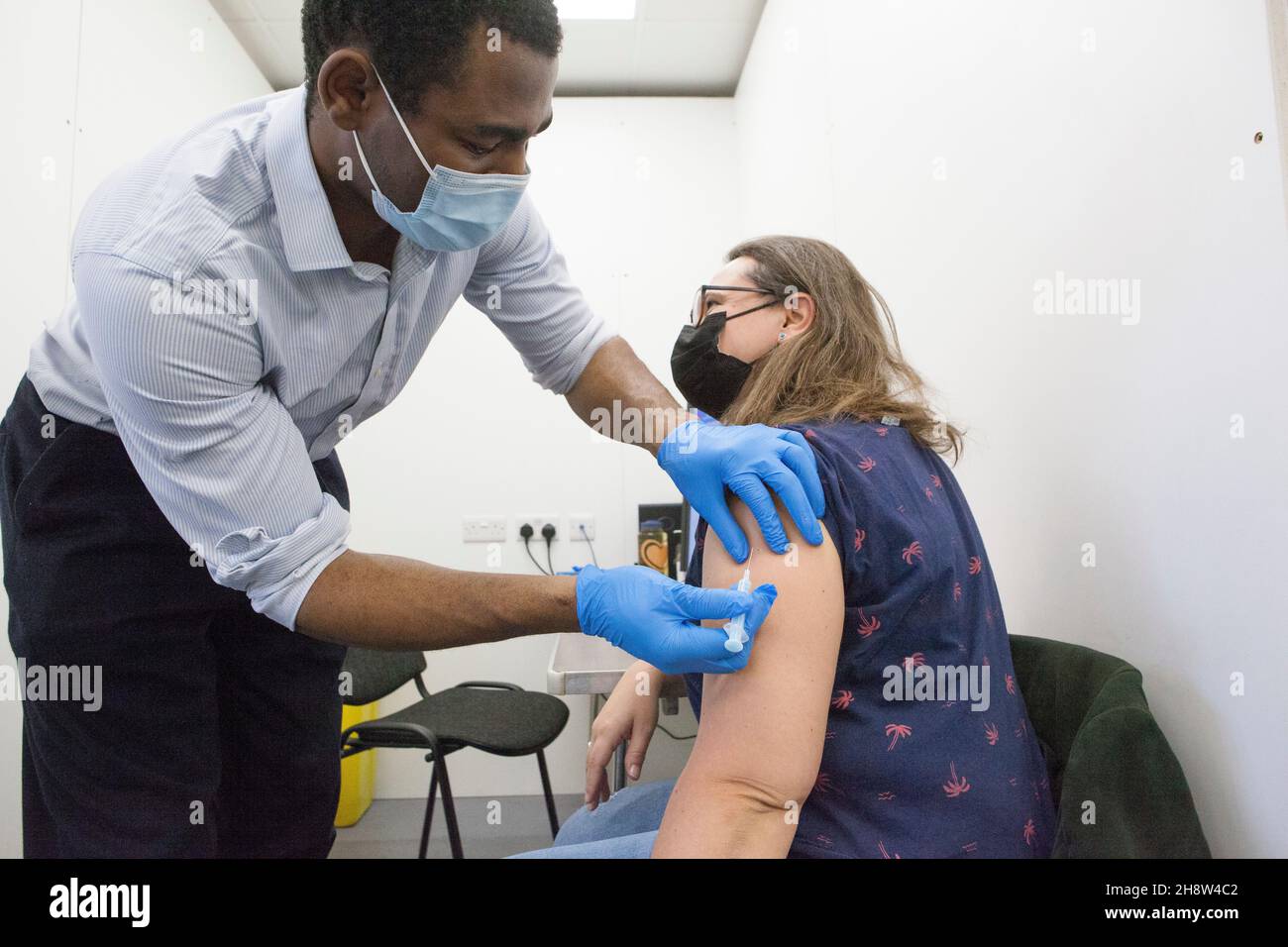 London, UK, 2 December 2021: Helen Eastman, 42, receives her Pfizer booster jab at Pearl Chemists pop-up vaccination centre in Tooting, south London. The government have promised to offer all adults a third vaccination dose by the end of January 2022 in the face of fears that the omicron varant could spread rapidly once it starts community transmission in the UK. Anna Watson/Alamy Live News Stock Photo