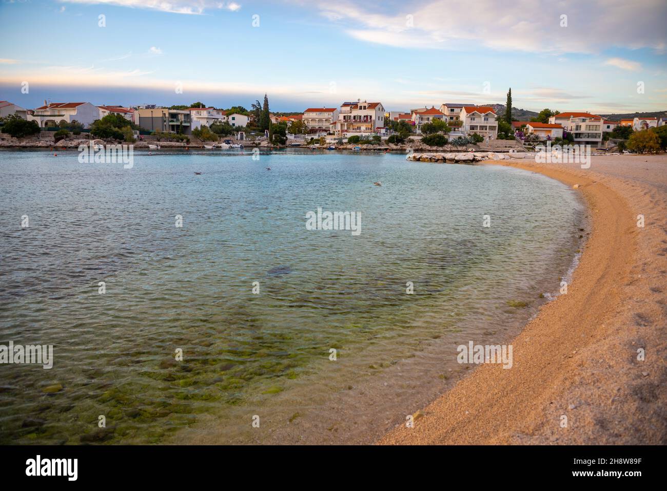 Rogoznica, Croatia - October 12, 2021: Beautiful area Lozica of Rogoznica town with sandy beach, white architecture and fishing boats at sunset time Stock Photo