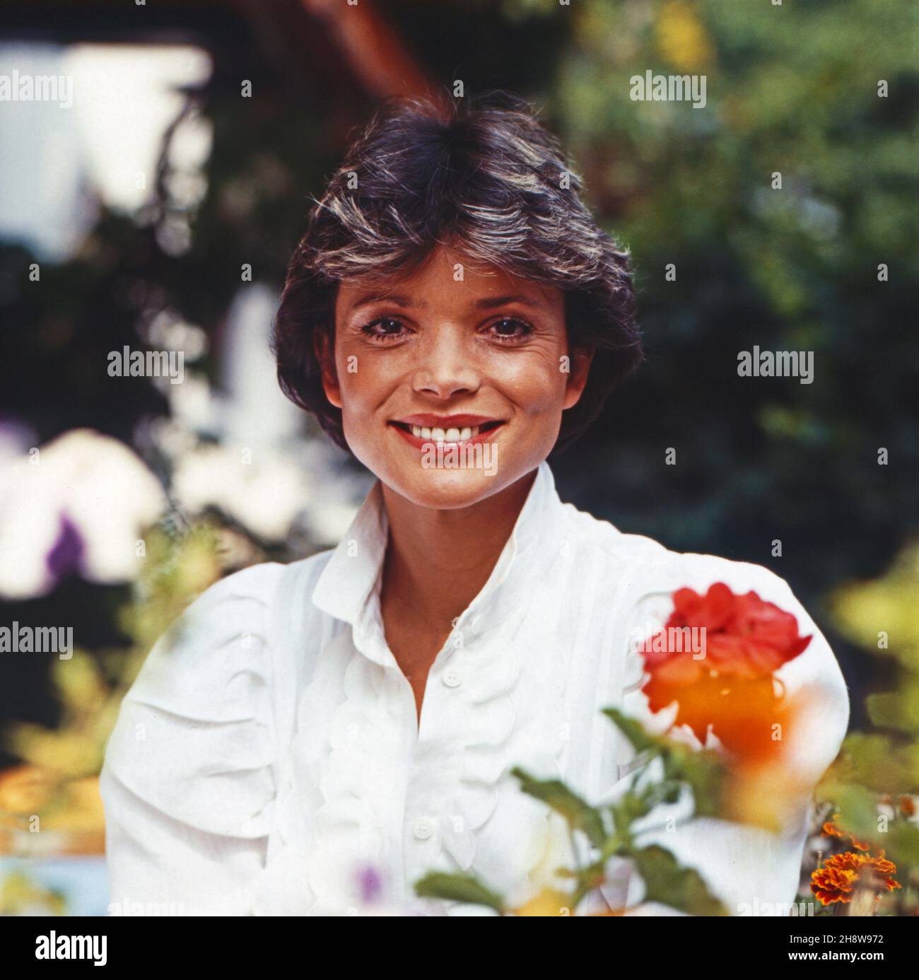 Uschi Glas, deutsche Schauspielerin, mit Blumen im Garten, Deutschland um 1980.German actress Uschi with flowers in the garden, Germany around 1980. Stock Photo