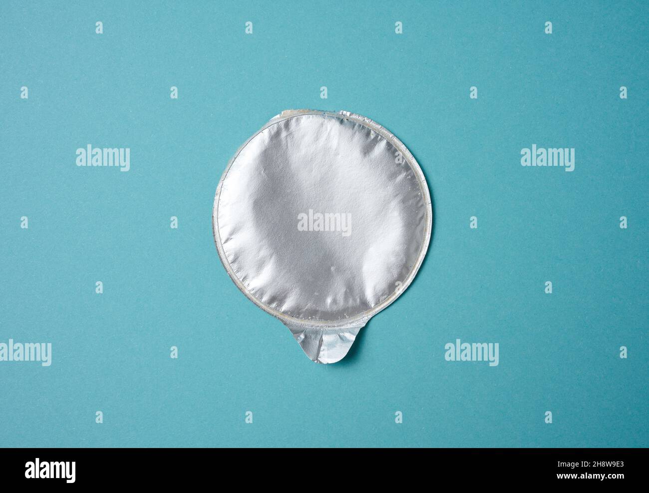 aluminum round lid from under the package with chips on a blue background, flat lay Stock Photo