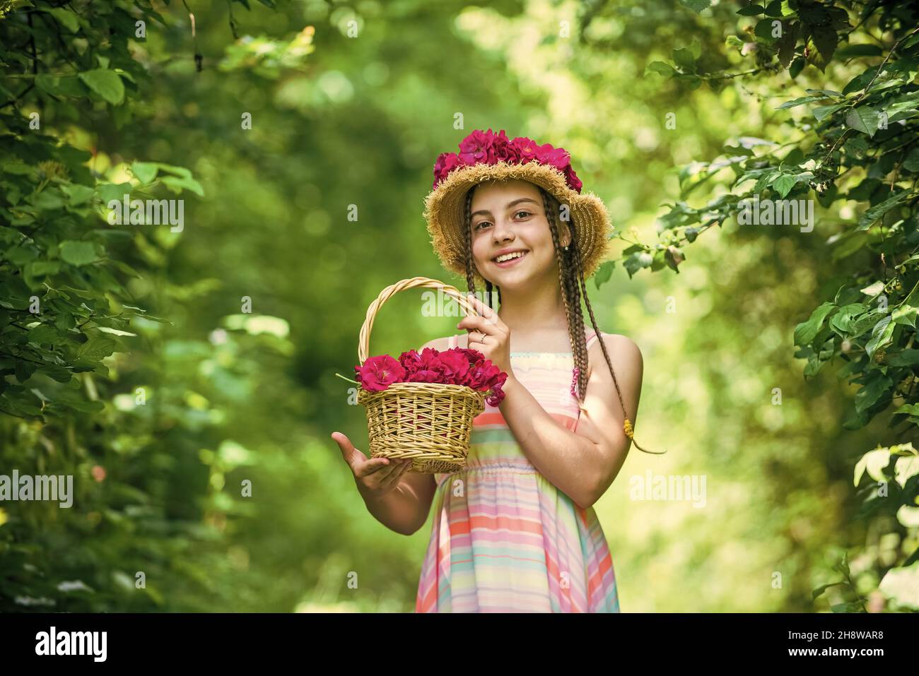 happy child girl in straw hat with rose flowers in summer nature ...