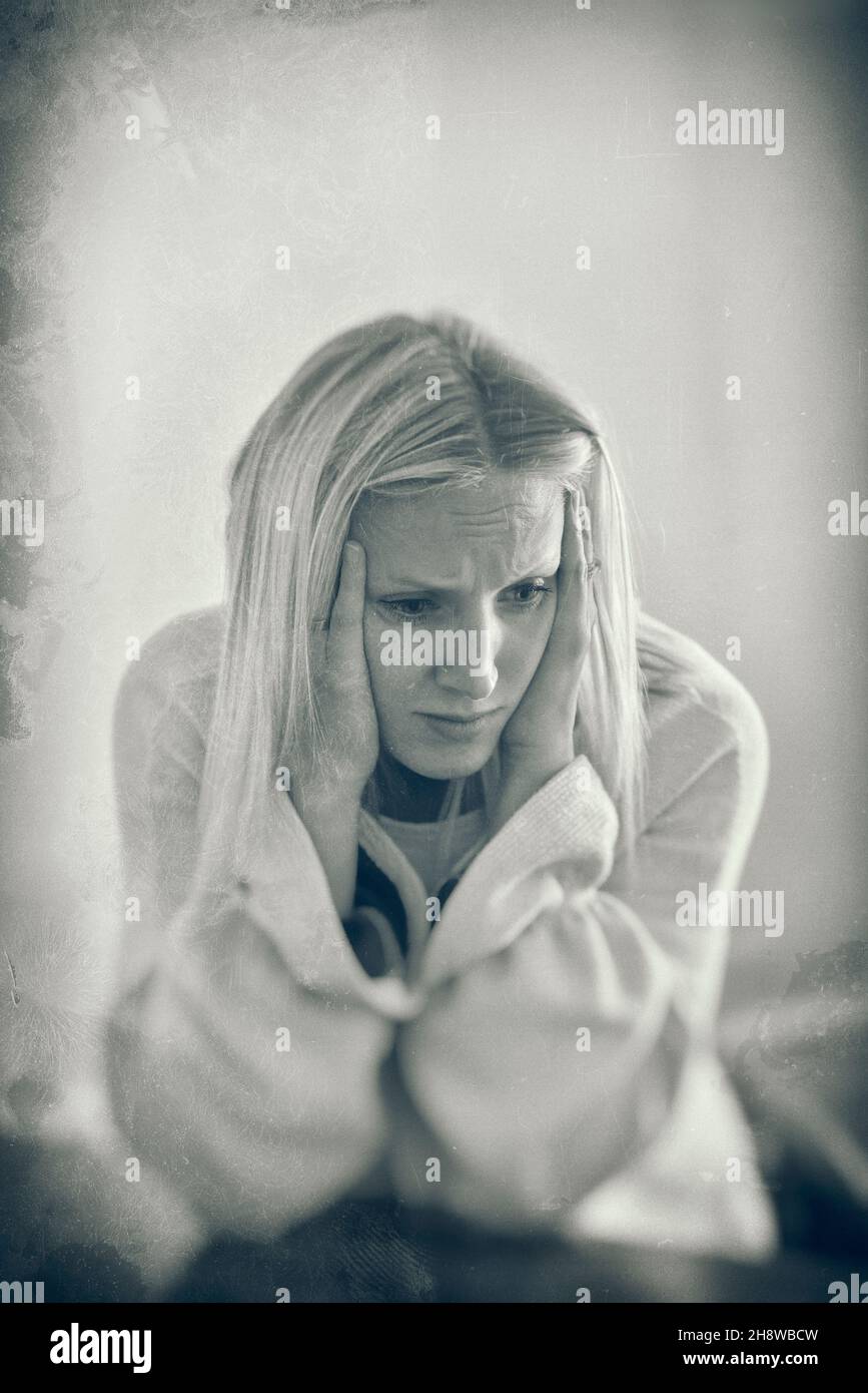 Young Woman Holding Her Head In pain suffering with a headache or migraine Stock Photo