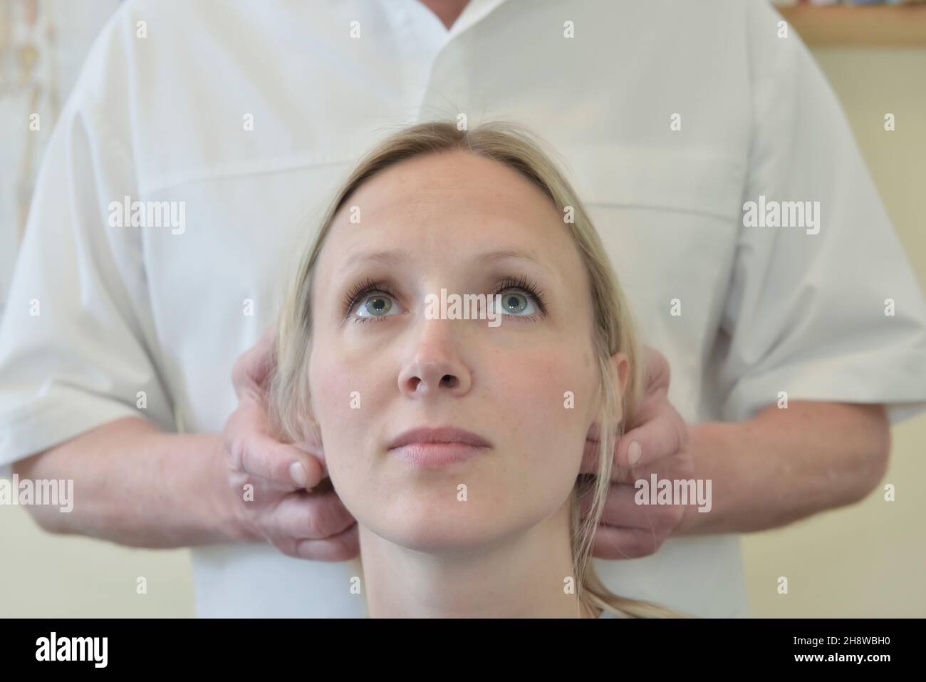 A male chiropractor adjusts the head, neck and spine of a female