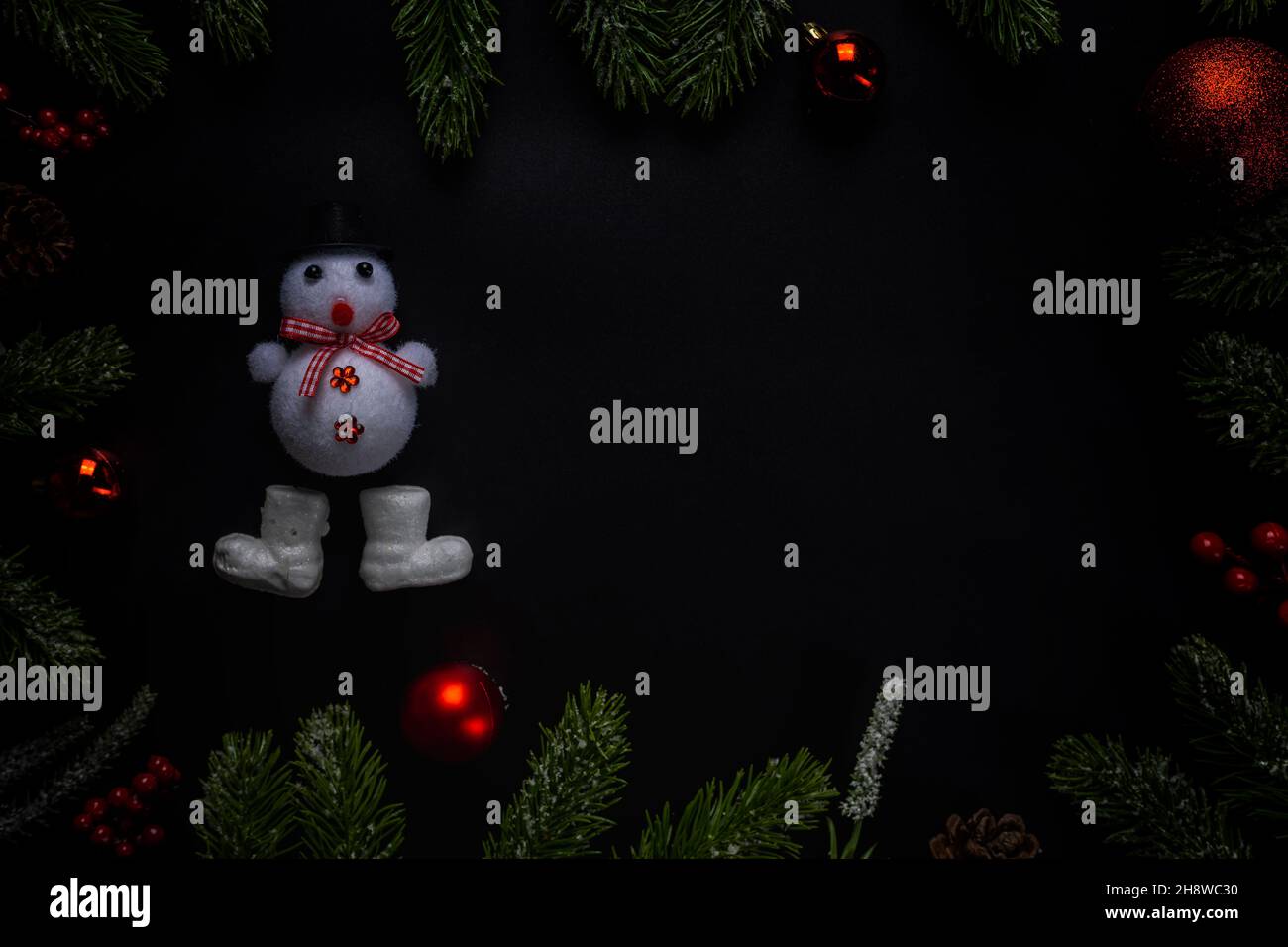 Christmas background with fir branches and red ball on dark and black ...