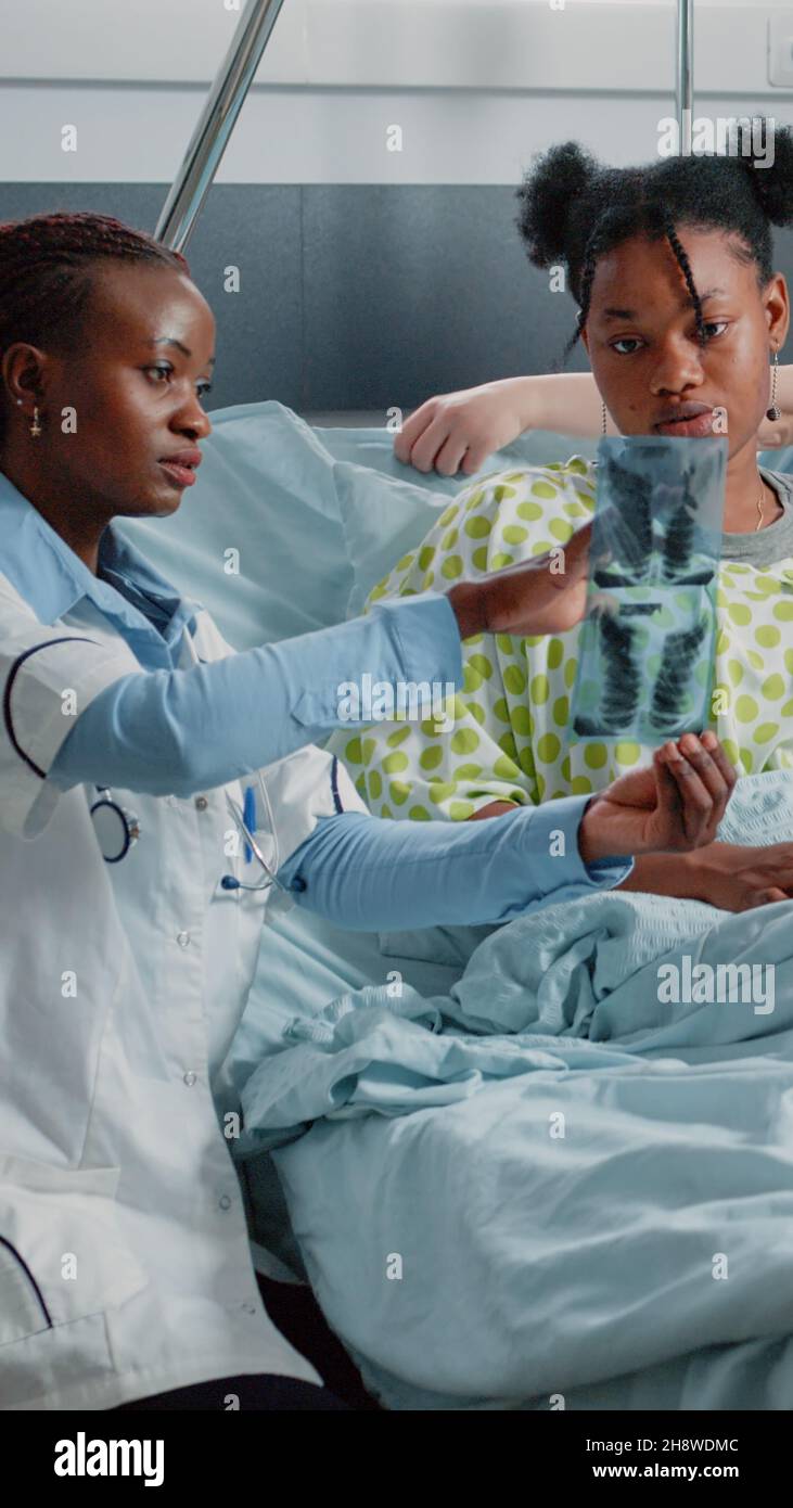 Physician showing radiography results to ill woman in bed. Medical ...