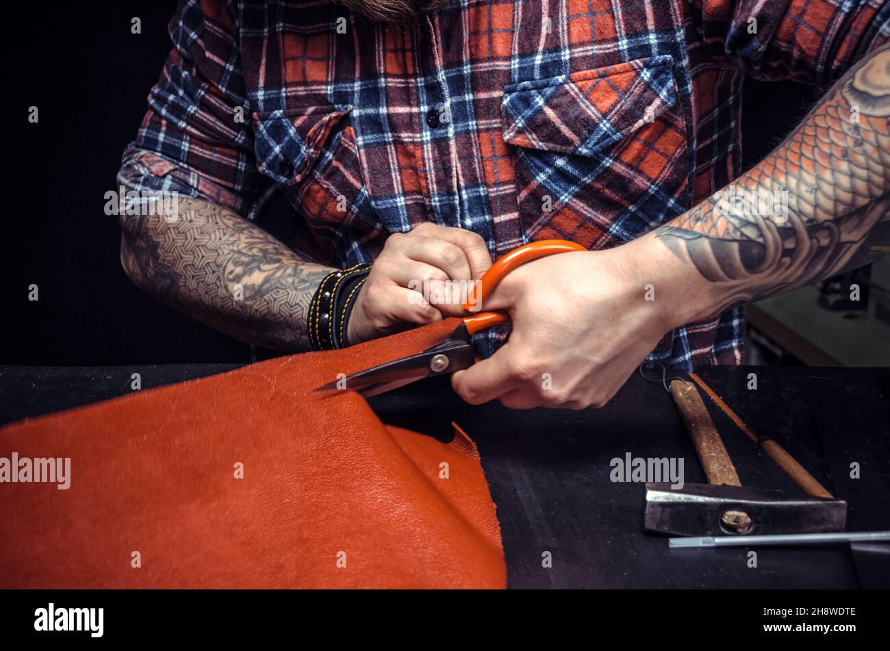 Man working with leather using crafting scissors Stock Photo