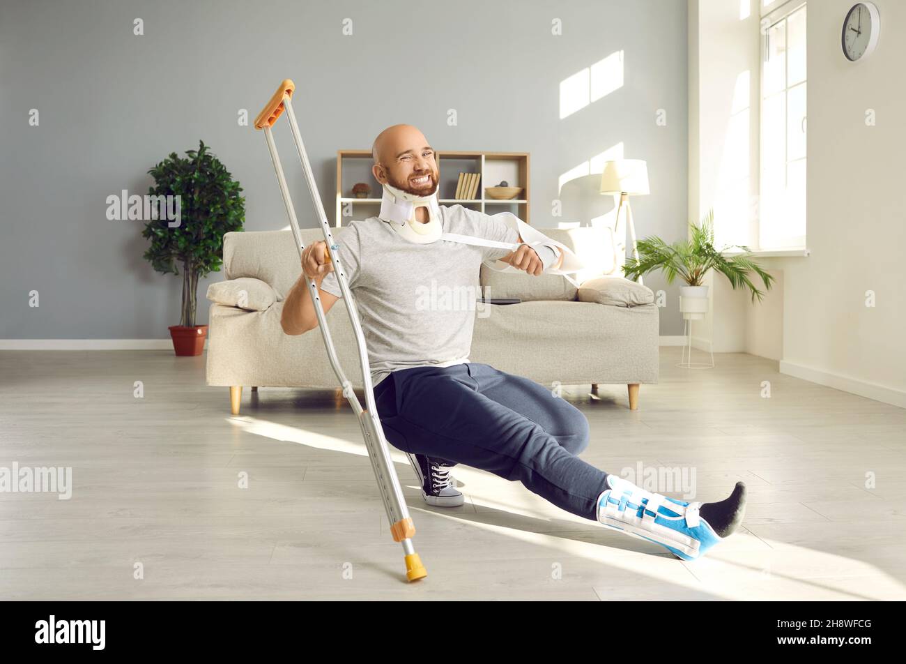 Happy, crazy patient with broken neck and other injuries having fun while recovering at home Stock Photo