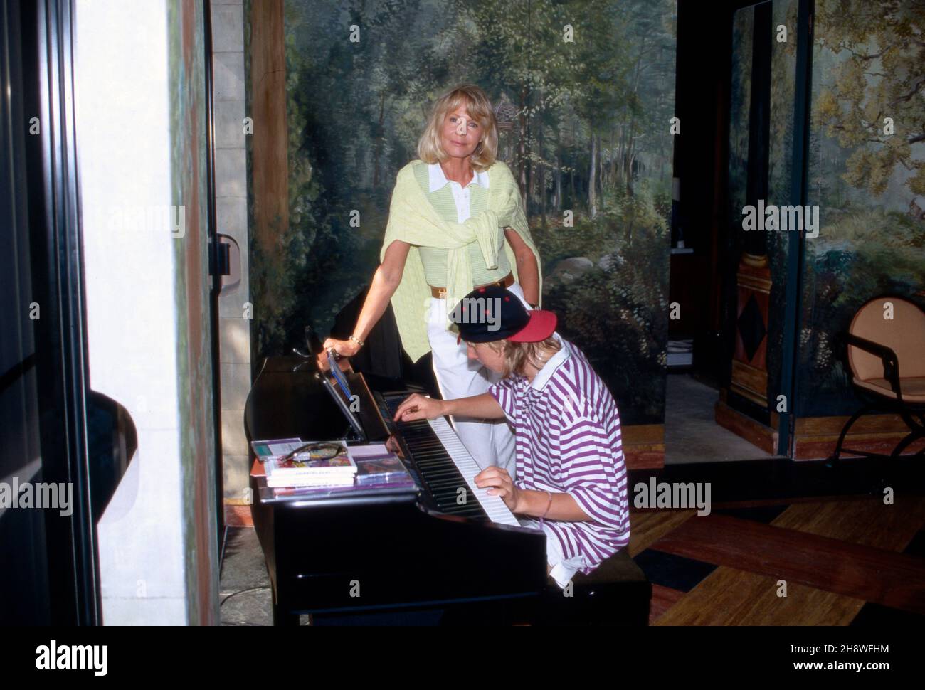 Gunter Sachs' Ehrfrau Mirja hat das Üben von Sohn Claus Alexander am Synthesizer im Blick in St. Tropez, Frankreich 1990er Jahre. Gunter Sachs's wife Mirja having a look to the exercises of son Carl Alexander on the synthesizer at St. Tropez, France 2000s. Stock Photo