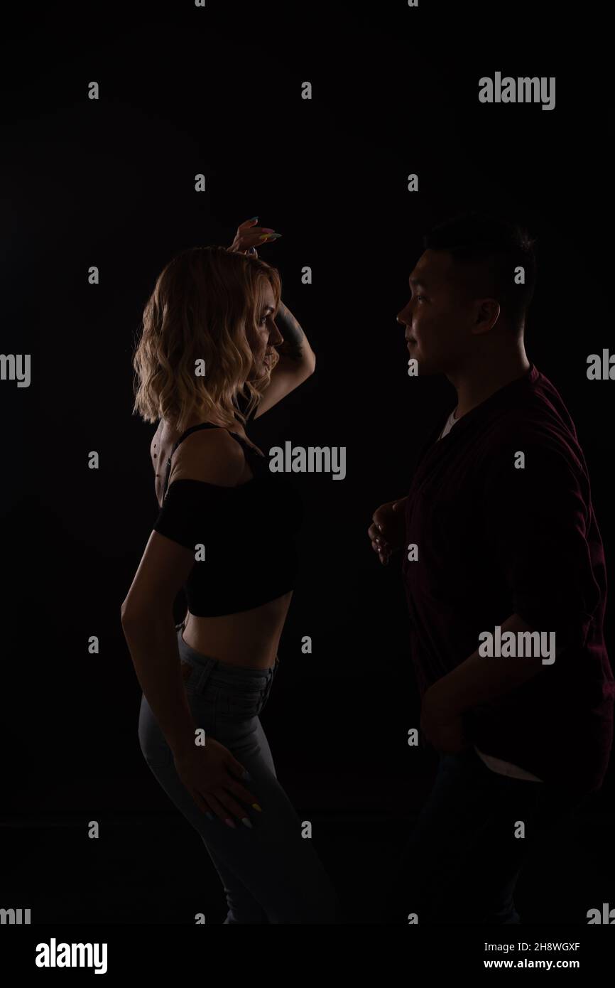 a man and a woman dance to music in the darkness of a disco Stock Photo ...