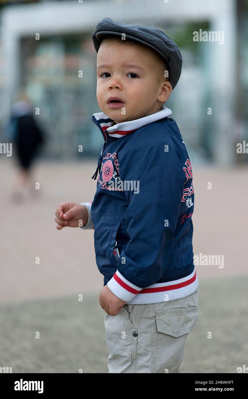 Rotterdam, Netherlands. The year old male Toddler curiously roaming the streets of Rotterdam Kop van Zuid while his mother is watching him outside the frame. Stock Photo