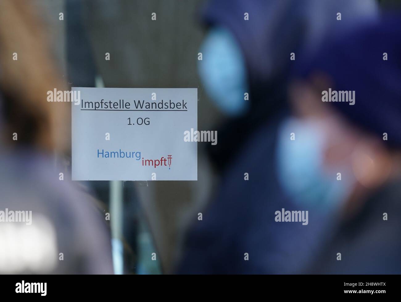 Hamburg, Germany. 02nd Dec, 2021. People willing to be vaccinated stand in a queue in front of the vaccination centre in the district of Wandsbek in front of a sign 'Impfstelle Wandsbek 1.OG Hamburg impft'. Credit: Marcus Brandt/dpa/Alamy Live News Stock Photo