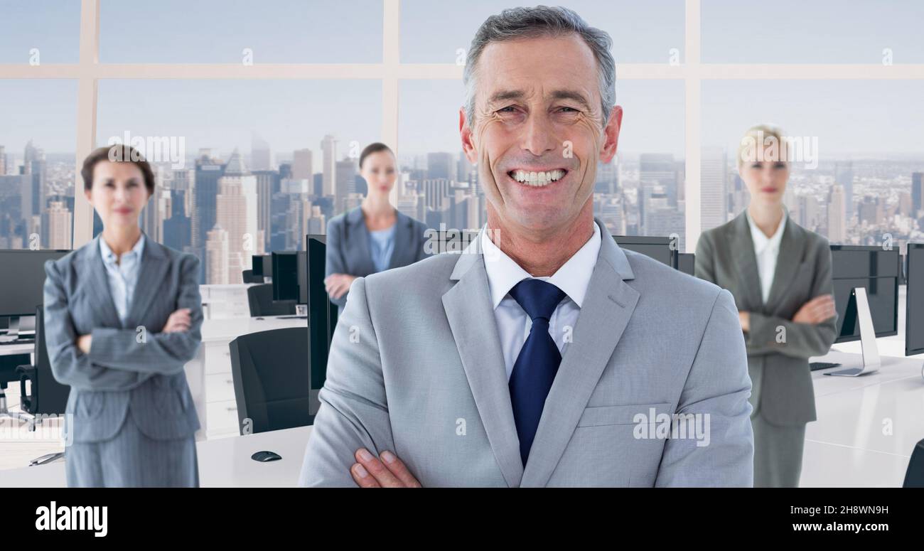 Portrait of smiling businessman standing ahead of businesswomen at modern office Stock Photo
