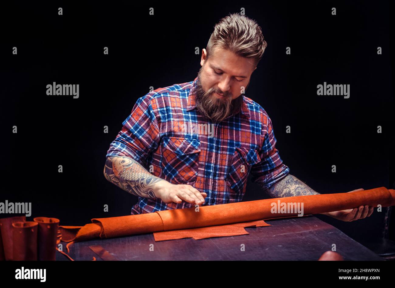 Artist working with leather processing a leather workpiece Stock Photo